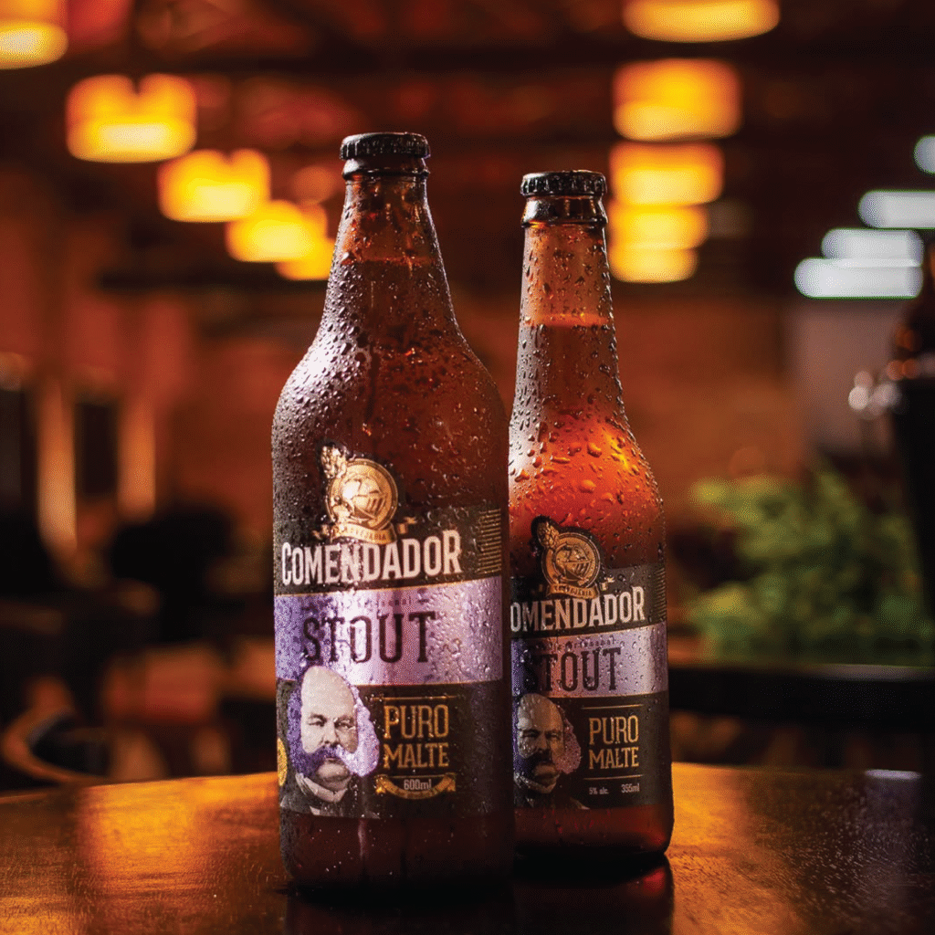 Rótulo da cerveja Comendador Stout puro malte em garrafas de 600ml e 355ml com acabamento em preto e roxo.
