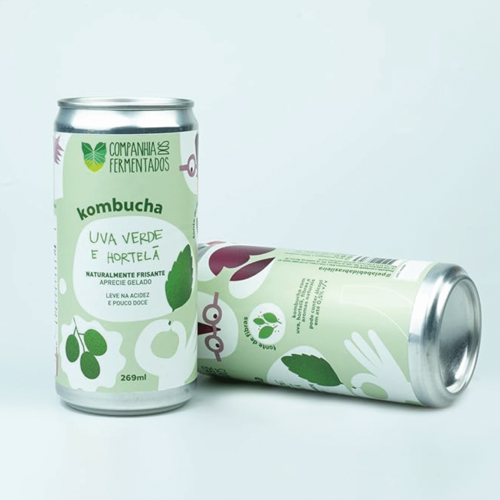 Lata de kombucha da Companhia dos Fermentados, sabor uva verde e hortelã, com rótulo adesivo envolvente em tons de verde claro e ilustrações minimalistas de folhas e frutas.