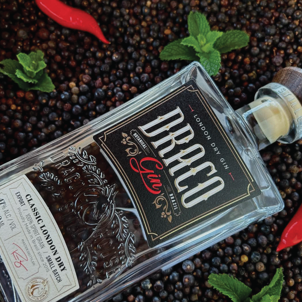 Rótulo sofisticado do Draco Gin London Dry em garrafa de vidro transparente com detalhes em relevo e tipografia clássica.